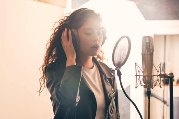 istock Pretty female singer recording in music studio 1334287231