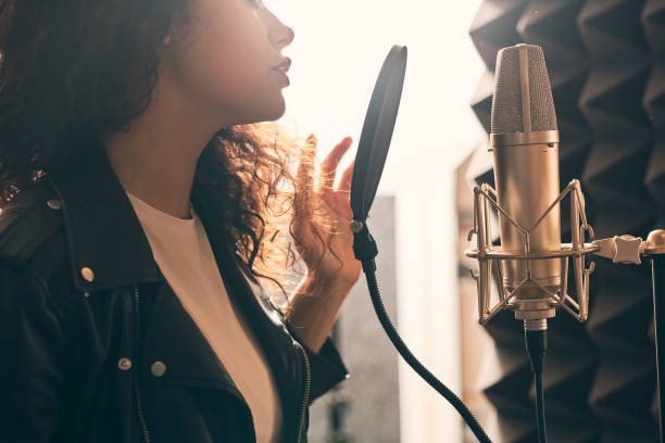 istock Pretty female singer recording in music studio 1334287233