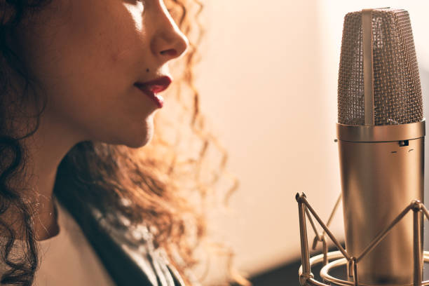 istock Pretty female singer recording in music studio 1334287241