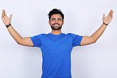 Successful young man with arms outstretched on white background