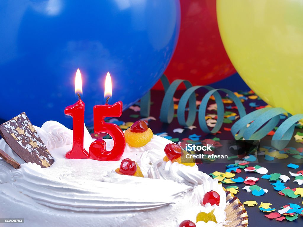 15th anniversary vanilla cake with balloons and confetti 15th. Anniversary / Birthday cake in a Party background with balloons and party strings. Birthday Cake Stock Photo