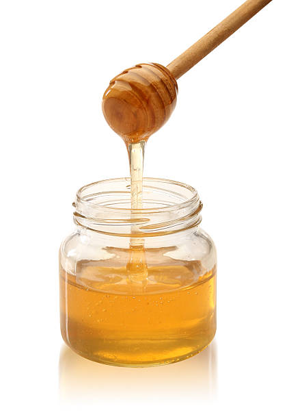istock Honey with wood stick pouring. 133428939