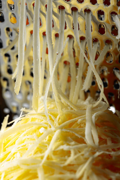 Grated cheese and grater. Concept: Italian cuisine, cheese, restaurant, and food. Selective focus.