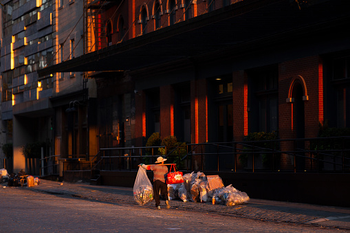 New York City, USA - August 30. 2019: Old lady collecting cans on the street in Tribeca.