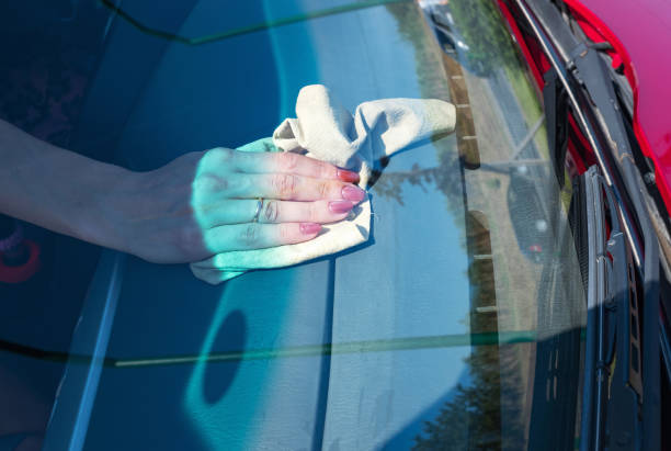 istock Woman's hand wiping car front panel with a microfiber at home. 1334292563