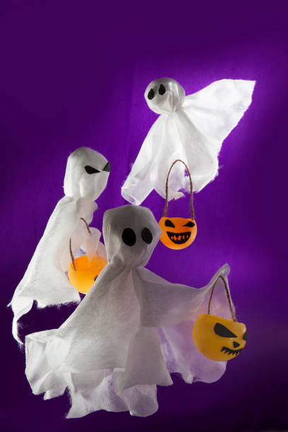 istock Decorative background for Halloween, white ghosts with pumpkins 1334297114