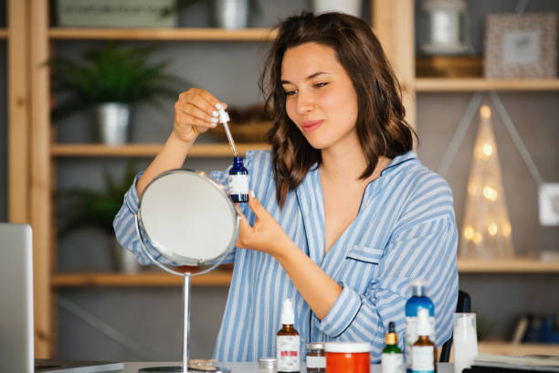 Young woman applying a serum to her face in her evening routine. stock photo