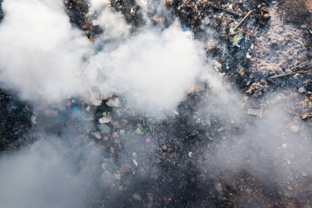 garbage and fire burn in landfill cause of air pollution, environmental damage and global warming. - incinerator imagens e fotografias de stock