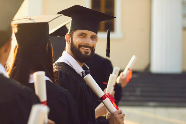 istock Smiling handsome man university graduate holding diploma with honors 1334304314