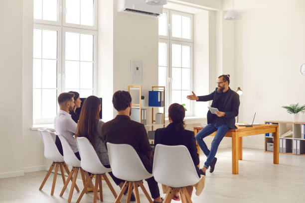istock Businessman or executive manager making presentation or training for sitting company workers 1334305411