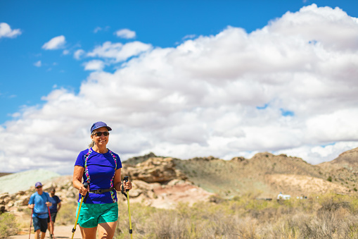 In Eastern Utah Mature Adult Couple Hiking in Desert Photo Series Matching 4K Video Available (Shot with Canon 5DS 50.6mp photos professionally retouched - Lightroom / Photoshop - original size 5792 x 8688 downsampled as needed for clarity and select focus used for dramatic effect)