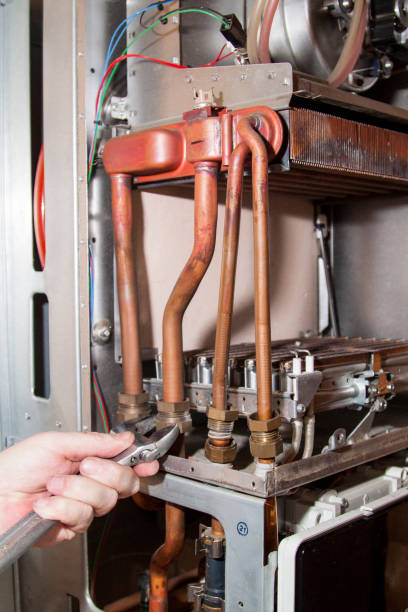 istock worker installs the heat exchanger after descaling on a workplac 1334314285