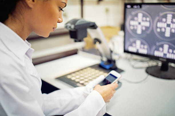 istock Woman is using mobile phone till working in circuit board factory 1334318645