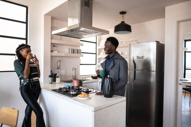 istock Young couple drinking coffee and talking in the kitchen at home 1334322646