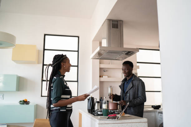 istock Woman working or doing home finances and man cooking at home 1334323061
