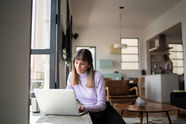 istock Young woman using laptop at home 1334323298