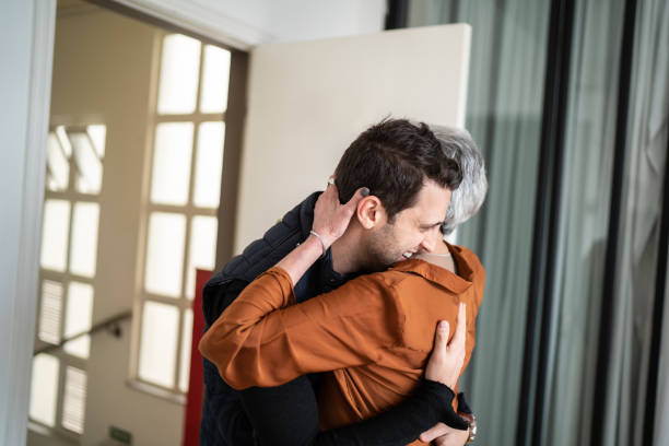 Senior woman greeting son at home