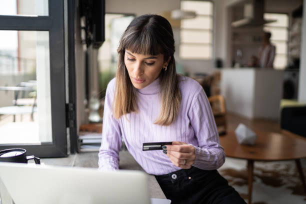 istock Young woman doing online shopping using credit card at home 1334323331