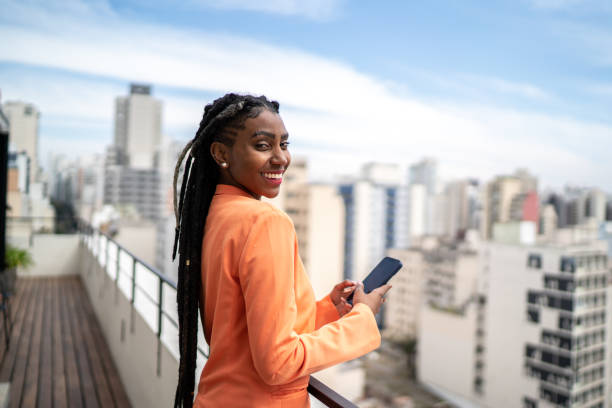 istock Portrait of a young woman using smartphone in a rooftop 1334323363