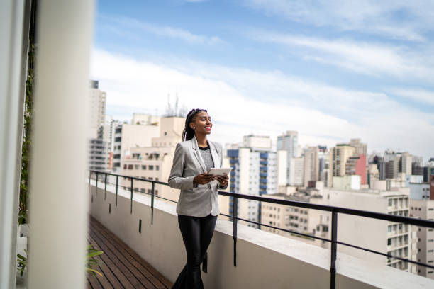 istock Young businesswoman contemplating and using digital tablet in a rooftop 1334323954