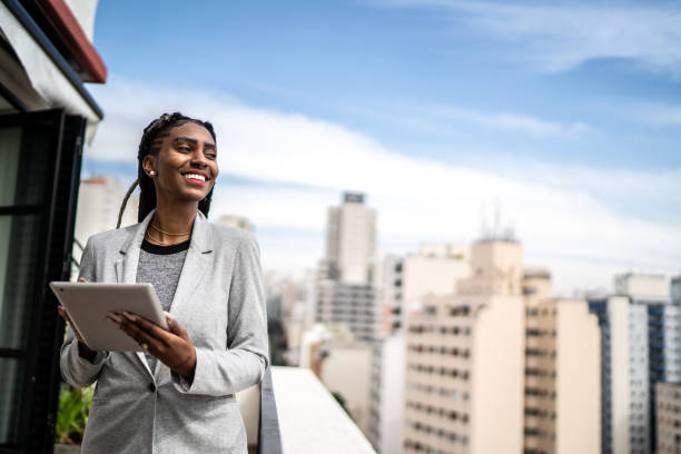 istock Young businesswoman contemplating and using digital tablet in a rooftop 1334323956
