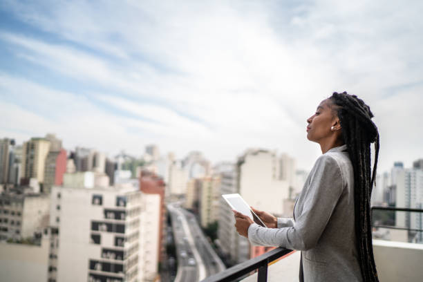 istock Young businesswoman contemplating and using digital tablet in a rooftop 1334323970