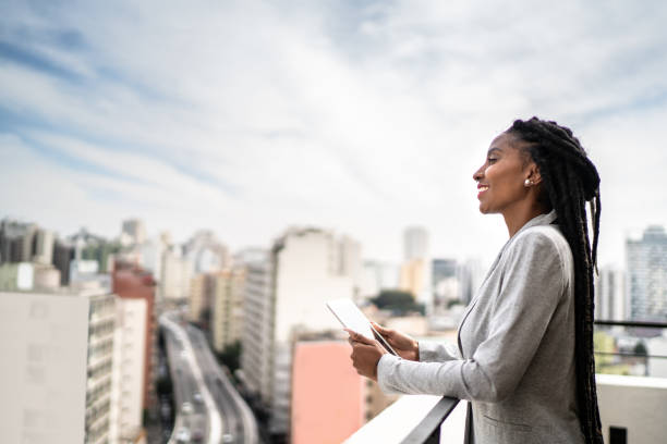 istock Young businesswoman contemplating and using digital tablet in a rooftop 1334323992