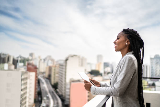 Young businesswoman contemplating and using digital tablet in a rooftop
