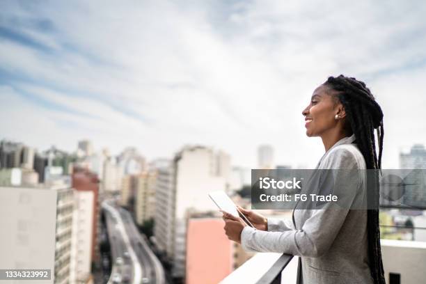 Young businesswoman contemplating and using digital tablet in a rooftop
