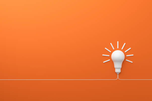 concept idée innovation ampoule sur fond orange. - ampoule à basse consommation photos et images de collection