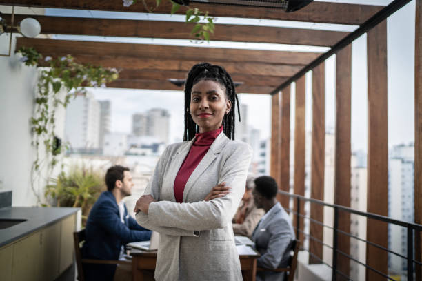 retrato de una mujer de negocios al aire libre - reunión de equipo en el fondo - fundador fotografías e imágenes de stock