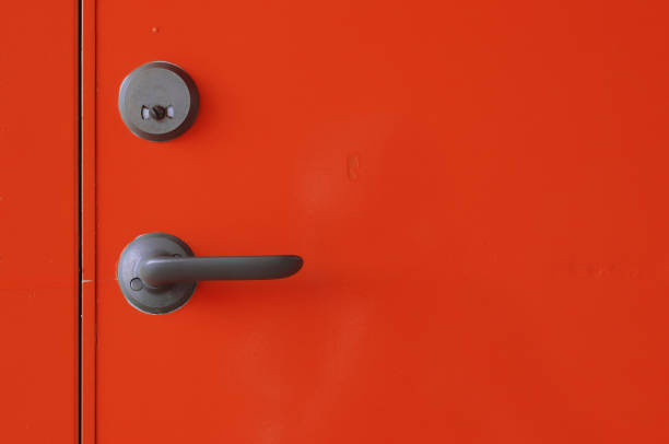 Close-up view of a red unlocked closed toilet door.