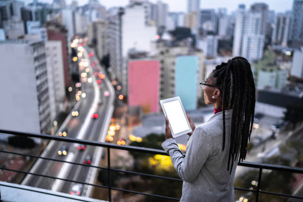 Businesswoman contemplating and using digital tablet in a rooftop