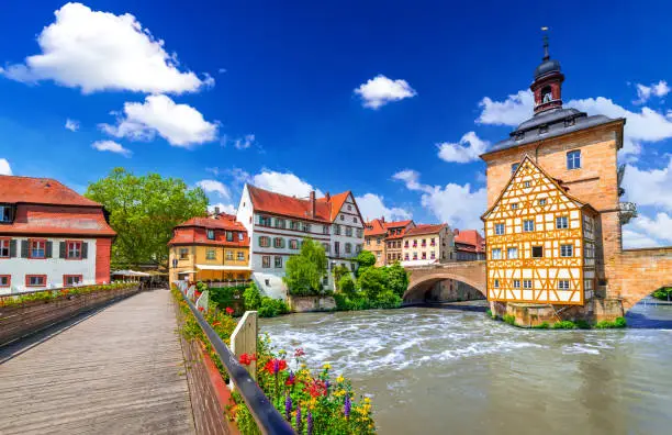 Bamberg, Germany. Half-timbered Town Hall and Regnitz River, old buildings and bridge decorated by flowers, Bavaria, Franconia.