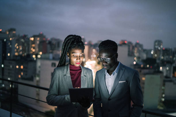 istock Business partners using digital tablet and talking in a rooftop 1334326980