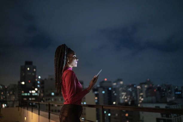 istock Happy young woman contemplating while using digital tablet in a rooftop 1334326983