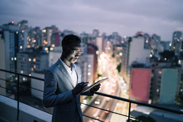 uomo d'affari che usa il tablet digitale in un tetto - roof men business city foto e immagini stock