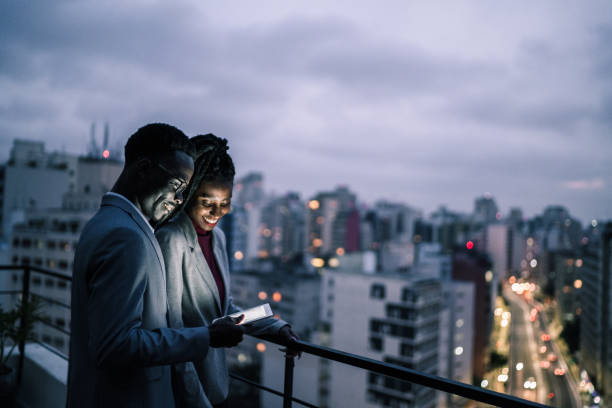Business partners using digital tablet and talking in a rooftop
