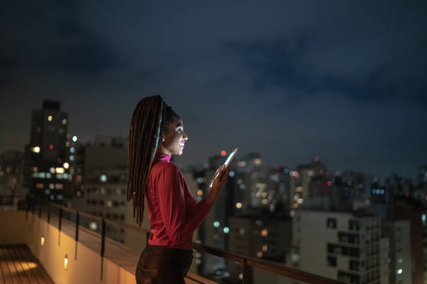 istock Happy young woman contemplating while using digital tablet in a rooftop 1334327036
