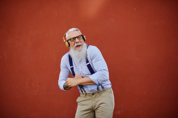 istock Cheerful elderly man dancing while listening to music from headset 1334328335