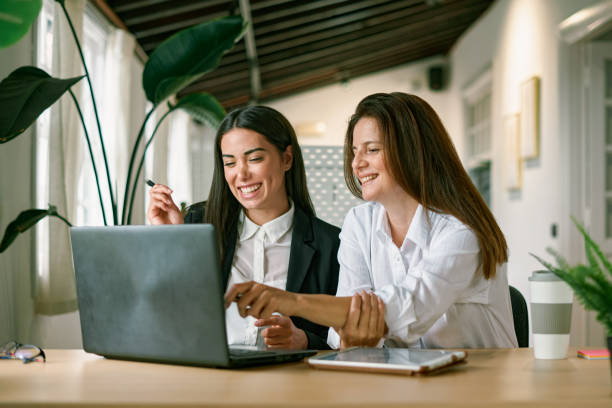 joyeuses collègues féminines utilisant un ordinateur portable ensemble - cheerful business person strategy people photos et images de collection