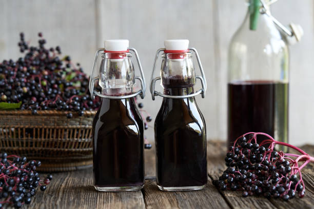istock Black elder syrup in two bottles with fresh elderberries 1334330070