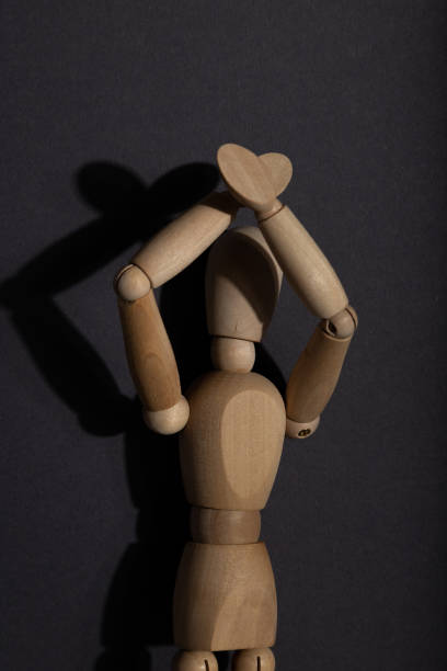 istock Wooden mannequin stands with raised hands on gray background. protest, attention concept. copy space, hard light. 1334330219