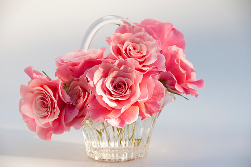 A sparkling crystal basket adorned with beautiful and fragrant pink roses.