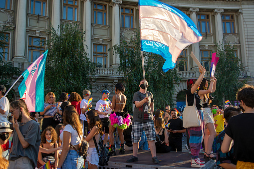 14.08.2021 Romania - Bucharest. A transsexual waving the trans pride flag on the stage set up at the University, at the lgbt pride parade.