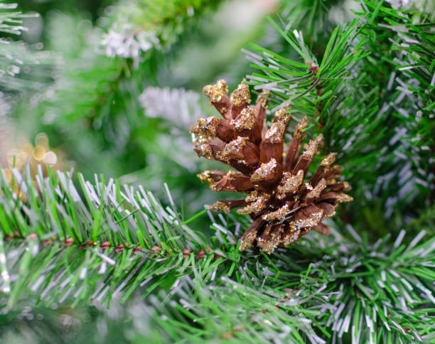istock pine cone on the background of an artificial Christmas tree 1334332145