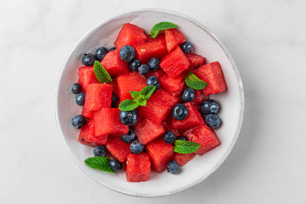 istock Watermelon and blueberry fruit salad with mint in a plate on white background. Top view 1334339201
