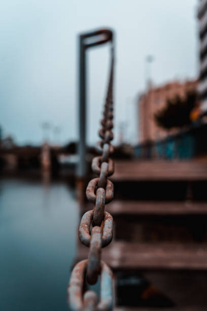 old oxide chains with wood table floor and sea river background