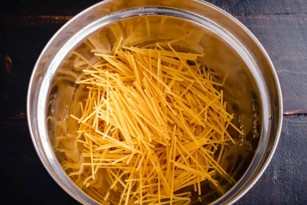 Overhead view of uncooked spaghetti noodles that have been broken into smaller pieces