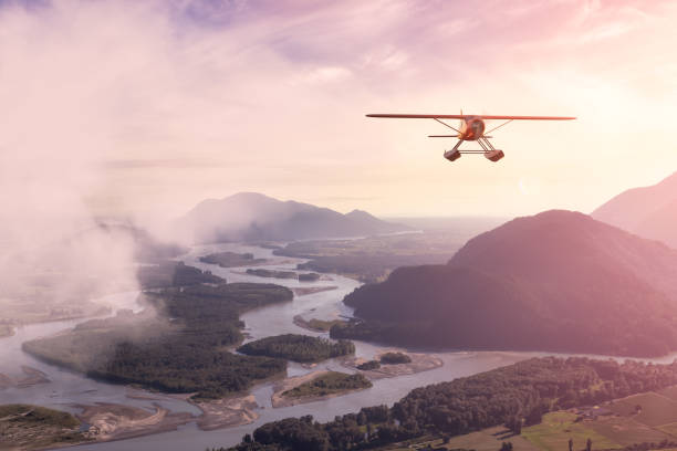 Composite Image of 3D CGI Seaplane flying over valley Adventure Composite Image of 3D CGI Seaplane flying over Fraser Valley in British Columbia, Canada. Summer Sunset Art Render. propeller airplane stock pictures, royalty-free photos & images